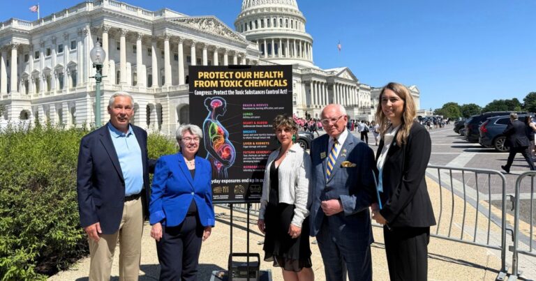 A group of five people stands in front of the U.S. Capitol, beside a sign advocating for health protections from toxic chemicals.